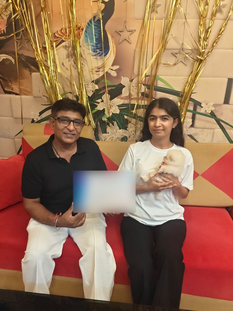 Father and daughter with their new Toy Pomeranian puppy in Delhi NCR